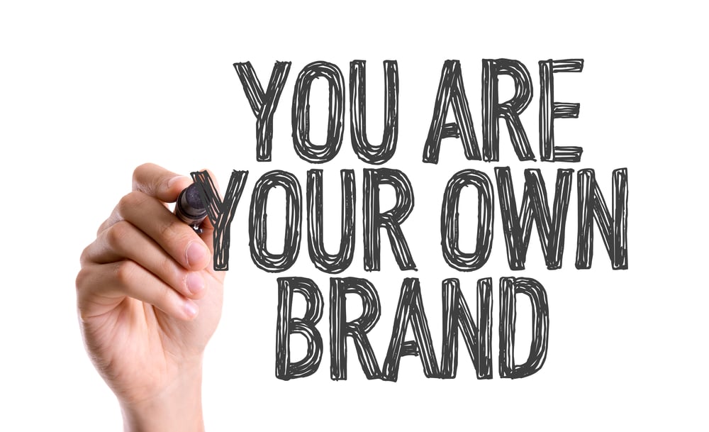 Hand with marker writing You Are Your Own Brand